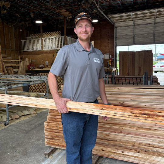 employee holding wooden fencing